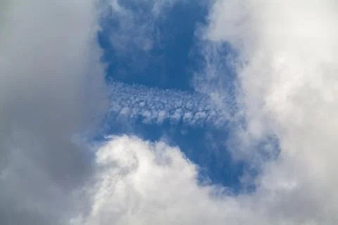 A hole in the dark clouds show a portion of blue sky Stock Photos