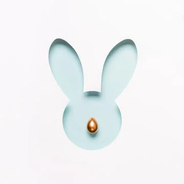 Hole Easter Bunny face made of cut paper and golden egg nose. Happy easter Stock Photos