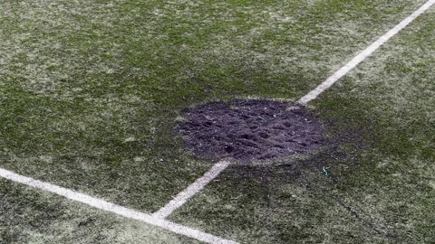 A hole in the ground from a cannon shell explosion filled with fresh earth 스톡 동영상 239378507