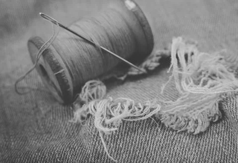 Hole in jeans. Needle with thread for darning jeans. Tools for work dressmake 写真素材