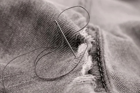 Hole in jeans. Needle with thread for darning jeans. Tools for work dressmake 스톡 사진