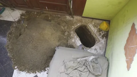 A hole made in the floor of a house next to all the earth taken Stockbeeldmateriaal 150671471