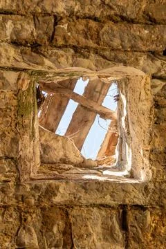 Hole in old stone wall through which you can see the sky Stock Photos