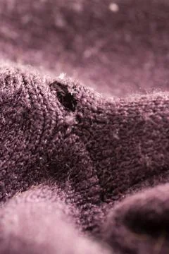 Hole on the purple sweater Stock Photos
