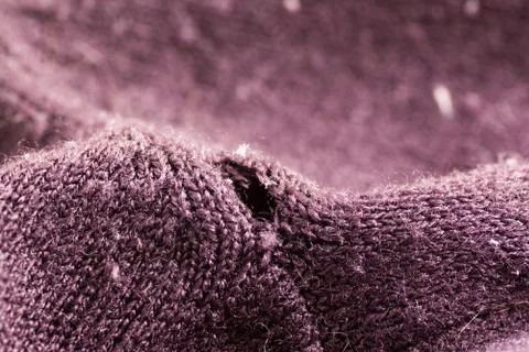 Hole on the purple sweater Stock Photos