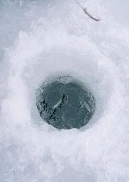 Hole in a river with a thick ice level fishing Фото