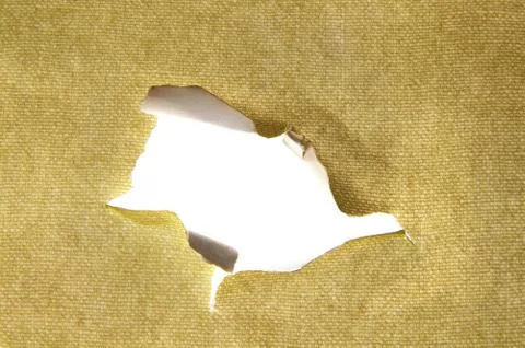 Hole torn in a piece of material, closeup Stock Photos