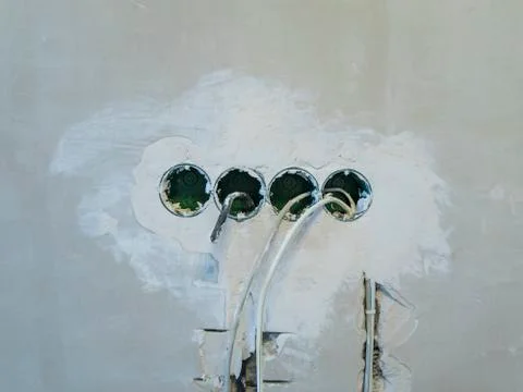 Hole in the wall under the socket Stock Photos