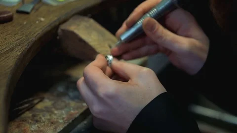 Holes are drilled in the silver ring to insert a precious stone Vídeo Stock 73607015