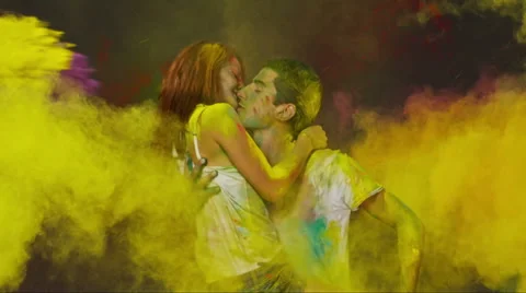 Holi colorful hits. Beautiful Young Couple in Love kiss and hug . Slow Motion. Stock Footage