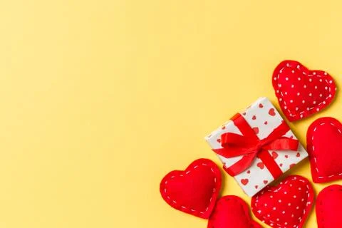 Holiday composition of gift boxes and red textile hearts on colorful backgrou Stock Photos