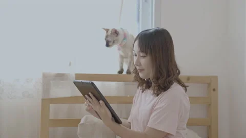 Holiday concept of 4k Resolution. Asian woman playing tablet in bedroom. Stock Footage 202050802