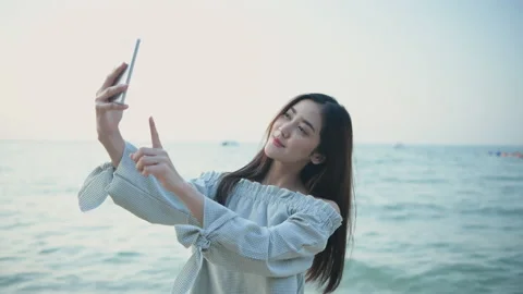 Holiday concept of 4k Resolution. Asian woman using mobile phone on the beach Stock Footage 228242542