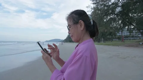 Holiday concept of 4k Resolution. An old Asian woman happily playing with a m Stock Footage 145730265