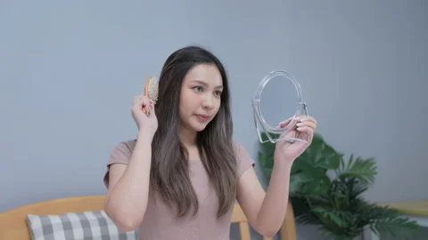 Holiday concept of 4k Resolution. Young Asian woman combing her hair in the b Stock Footage 166169269