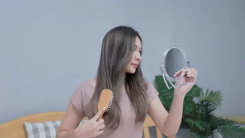 Holiday concept of 4k Resolution. Young Asian woman combing her hair in the b Stock Footage 170195305