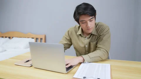 Holiday concept of 4k Resolution. Young Asian man working in the bedroom. com Stock Footage 170391719
