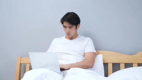 Holiday concept of 4k Resolution. Young Asian man working in the bedroom. Stock Footage 208570020