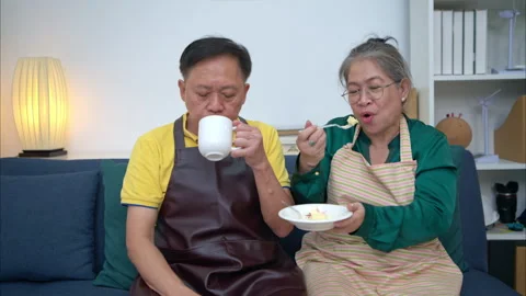 On a holiday, an elderly couple tests out handmade desserts at home Stock Footage 319535647