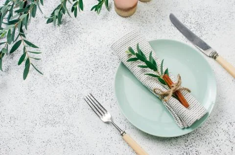 Holiday elegant table setting with linen napkin, sprig and cinnamon Stock Photos