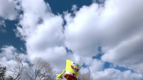 Holiday foldable sponge Bob figure on blue sky and white clouds background. Stock Footage 191930234