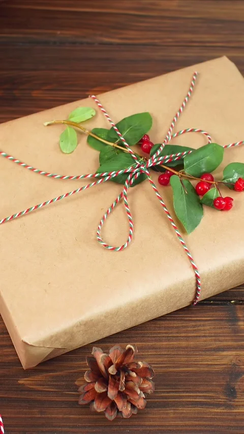 Holiday gift wrapping, Decorative present adorned with foliage and berries Stock Footage 322508150