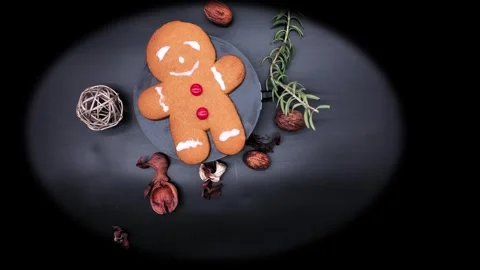 Holiday gingerbread cookie with red candy buttons, on black background turn.. Stockbeeldmateriaal 314675047