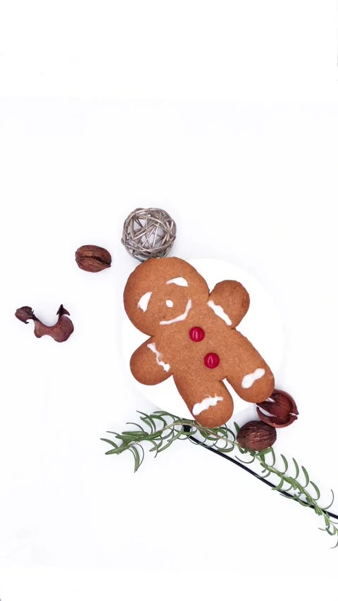 Holiday gingerbread cookie with red candy buttons, turning alongside the walnut Stock Footage 314675055