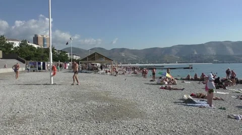 Holiday Makers on Pebble Beach in Summer Heat in Resort Southern City Stock Footage 65408331