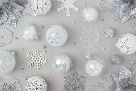 Holiday pattern made silver and white shiny christmas decorations on grey bac Stock Photos
