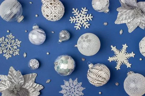 Holiday pattern made silver and white shiny christmas decorations on blue bac Stock Photos