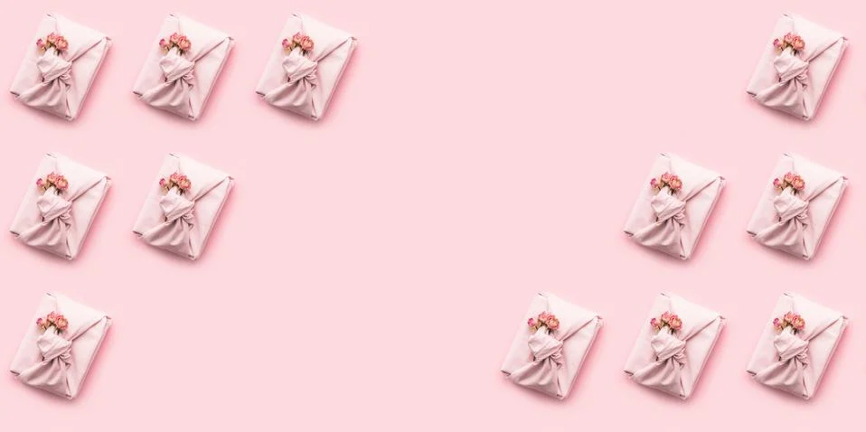 Holiday pattern present gift wrapped in a Furoshiki style cloth pink background Stock Photos