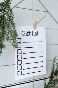 Holiday preparation paper note with GIFT LIST checklist text. Vision board with Stock Photos