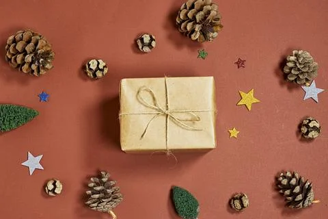 Holiday scene featuring a small brown paper-wrapped gift tied with twine, surrou Stock Photos