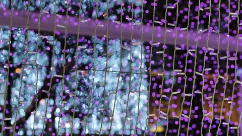 Holiday string lights creating bokeh effect in a city street at night Stock Footage 337061920