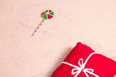 A holiday themed composition featuring a wrapped present and a candy treat pl Fotos de archivo