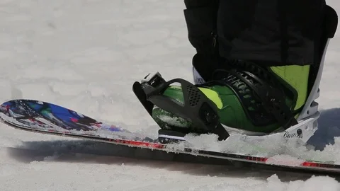 Holidaymaker puts on snowboard Stock Footage 73353286