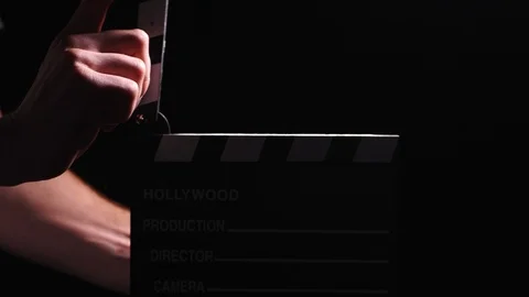 Hollywood production clapperboard clacking with powder dust in a low light Video stock 103042859