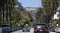 Hollywood Sign on the Hillsides of Los Angeles Hills Street Cars Passing Sunny HD Footage
