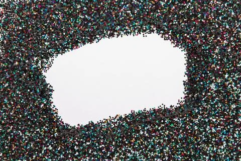 Holographic glitter on black background with empty blank space in the center. Stock Photos