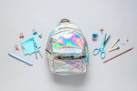 Holographic school backpack and different stationery on grey background Stock Photos