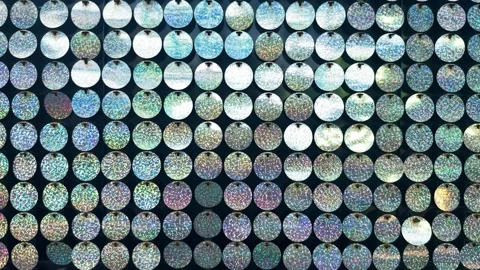 Holographic sequin wall of small circular discs reflecting light into glittering Stock Footage 329099601