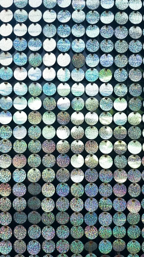 Holographic sequins forming an abstract, shimmering pattern, reflecting light Stock Footage 329488491