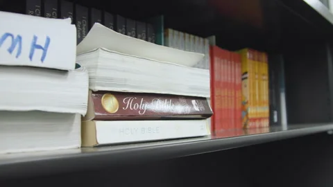 Holy Bible on bookshelf in library at prison Video stock 339106007