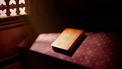 Holy Bible in rays of light falling into a confessional. Christian chapel detail Stock Footage 145767562