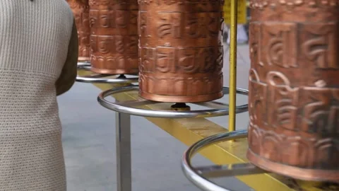 Holy buddhist rolling wheels at monastery spinning by devotee at day Stock Footage 316288011