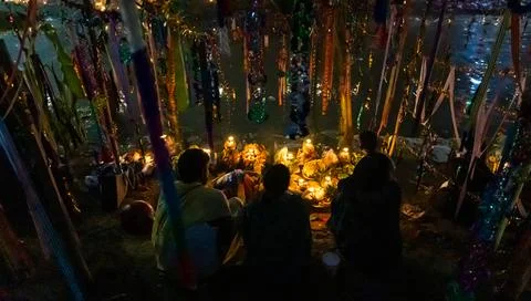 Holy chhath puja devotee offering daali with traditional oil lamp at riverban Фото