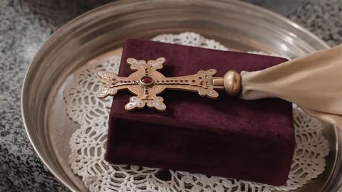 The Holy cross with red decorations lies on the Bible . Stock Footage 128663357