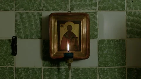 Holy icon on a green wall with lit candles. Stock Footage 221844264