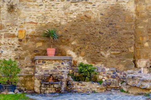 The Holy spring of water flows from the ancient monastery wall Stock Photos